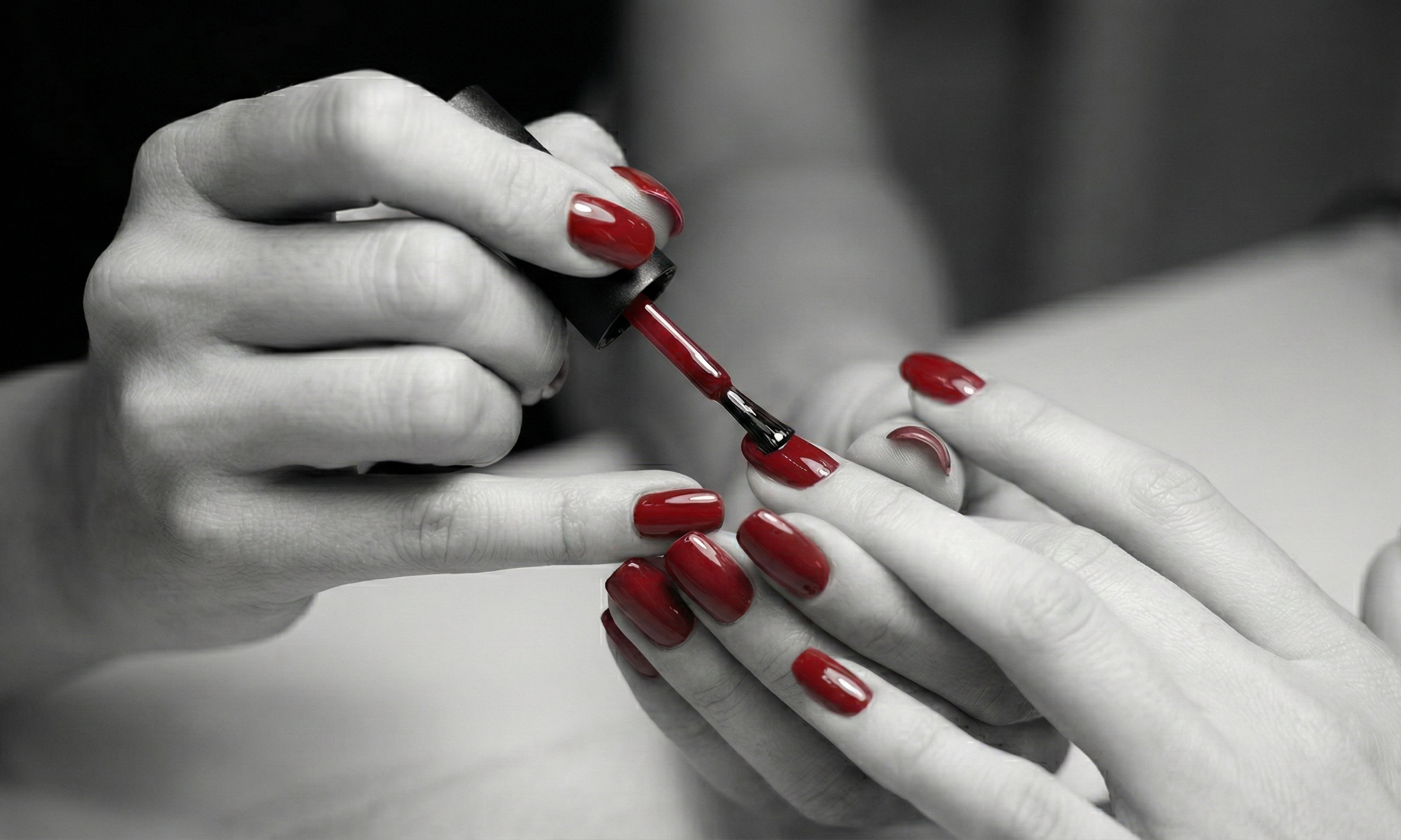 Applying red nail polish